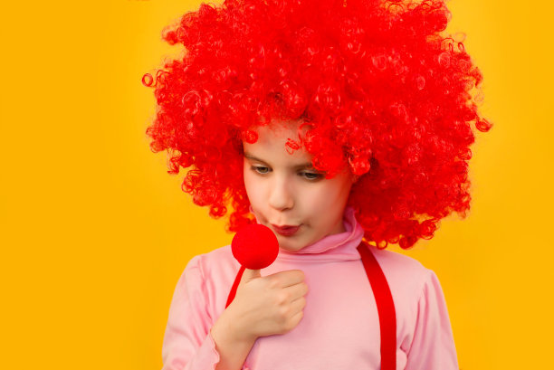 小丑小女孩吹伤了手指。4月1日的笑话。图片下载