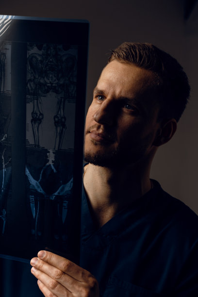 医生拿着新冠肺炎患者的x线扫描片。通过电脑断层扫描。身穿医袍的外科医生在看深色背景上的扫描图。Mri用于健康诊断图片下载