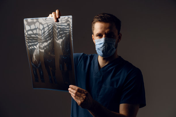 医生用x线扫描冠状病毒新冠肺炎患者。通过电脑断层扫描。身穿医袍的外科医生在看深色背景上的扫描图。Mri用于健康诊断图片下载