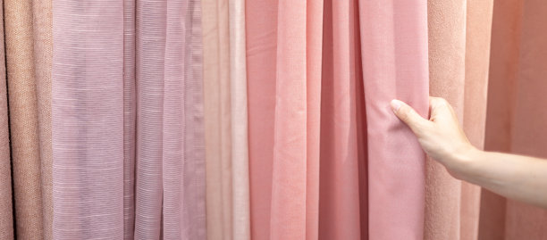女性手握窗帘，决定着棉窗帘的质量。图片下载