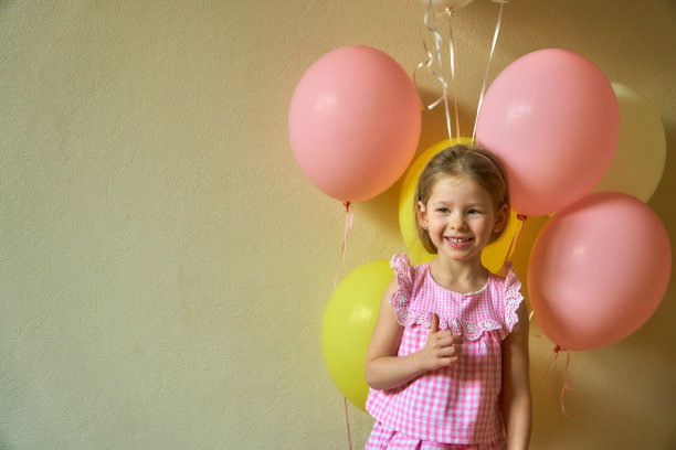 有气球的小女孩。美丽可爱的女孩在度假。快乐快乐的孩子微笑着，拿着很多气球。图片下载