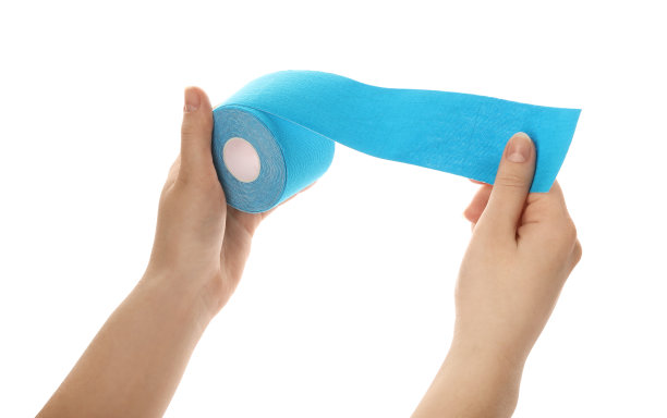 女人与明亮的运动胶带卷在白色的背景，特写图片下载