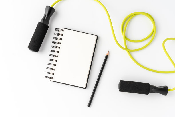 健身配件与空白笔记本在白色的背景。健身运动的概念图片下载