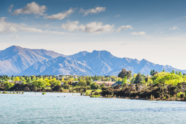 皇后镇和它的港口——五颜六色的建筑和船只横跨水面驶向码头和海岸线图片下载
