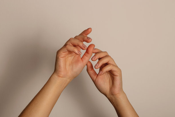 女人的手举起来。黑色背景上的简约美甲图片下载