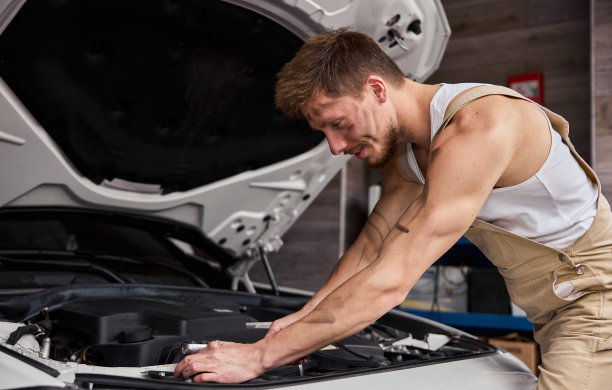 一个修理工在他的车库里工作的肖像。图片下载