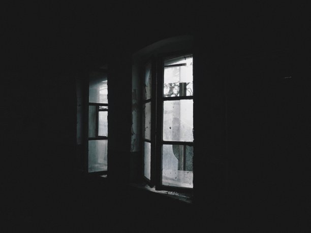可怕的窗户。在一个废弃的房子里。没有窗帘的破窗户。乏味的东西。光线透过破旧的木框架和破碎的玻璃照射进来。放弃和无用的概念图片下载