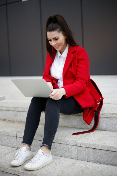 年轻的商业女性在户外使用笔记本电脑。库存图片图片下载