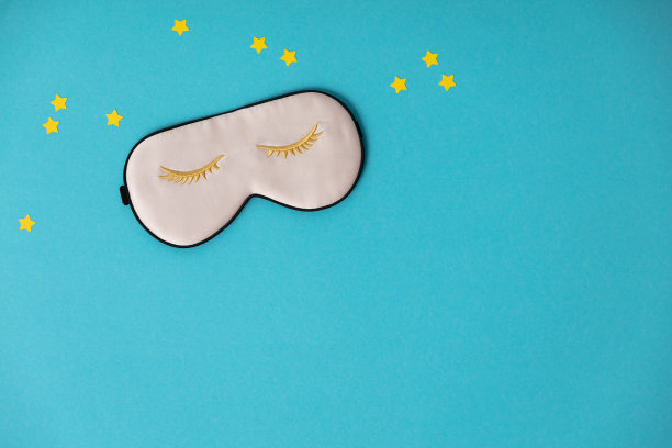 粉色睡眠面膜和蓝色背景上的纸星星，休息的概念，睡眠质量，晚安，失眠，放松图片下载