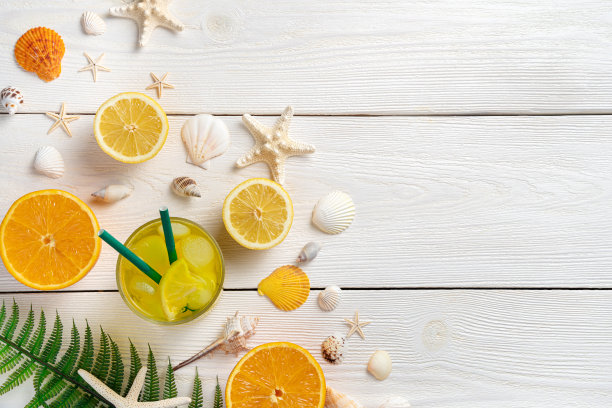 以夏季水果和清凉饮料为背景。橘子，柠檬，果汁和贝壳在白色的背景上图片下载