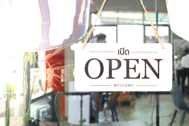 在餐厅和咖啡店的门上挂着开阔的招牌，在大门入口处挂着商业招牌，告诉顾客商店已经准备好提供服务。图片下载