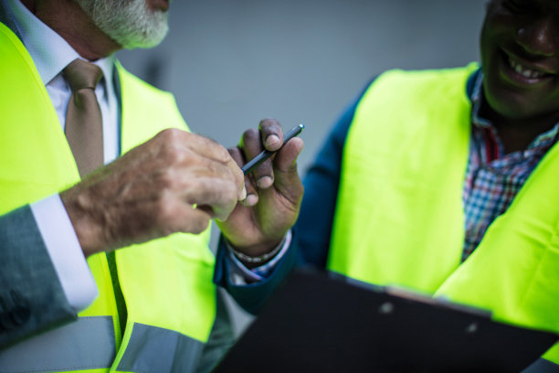 工程师签署承包商。外面有两个商人。注意力集中在手上。图片下载