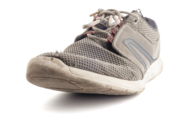 一只破旧的运动鞋孤立在白色的背景上图片下载