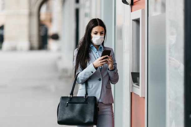 戴着防护面具使用ATM机的妇女图片下载