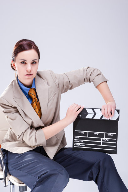 严肃的白人女性的肖像摆在米色西装在椅子与Actioncut室内。垂直方向图片下载