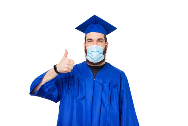 照片中的男学生竖起大拇指，戴着毕业帽和学士图片下载