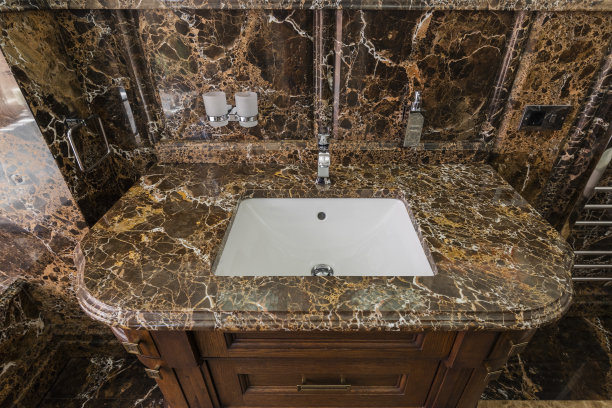 大理石浴室石材表面家具上的陶瓷白色脸盆图片下载