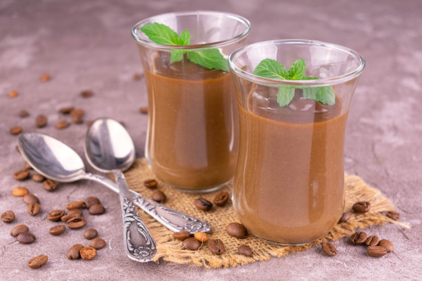 在灰色的背景上装饰有薄荷的两款甜点咖啡慕斯。特写镜头。图片下载