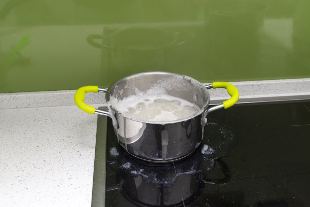 食物从感应炉上的锅里沸腾出来图片下载
