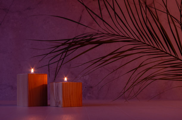 美丽的亚洲家庭装饰与燃烧的蜡烛和棕榈叶在温暖的紫色和橙色的夜晚灯光，复制空间。图片下载