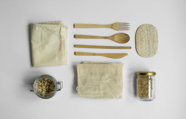 “零浪费”。一套环保竹餐具，网眼棉袋，玻璃罐和丝瓜海绵。塑料是免费的。自然和可重复使用的物品配件在灰色表面。图片下载
