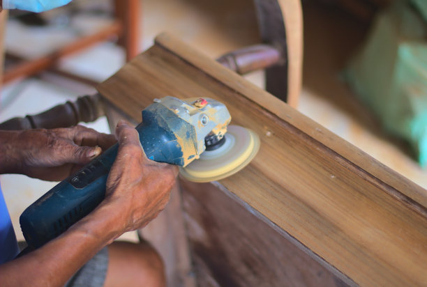 工匠的手抛光旧颜色从木桌与机器。一个老人使用电动砂光机和砂纸的特写照片。图片下载
