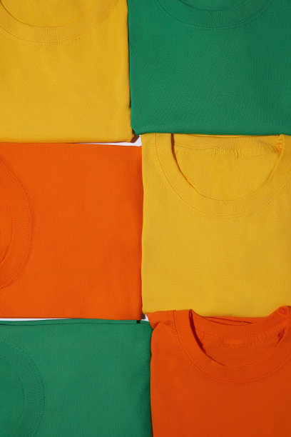 折叠多彩的黄、橙、绿棉质t恤。t恤模型图片下载
