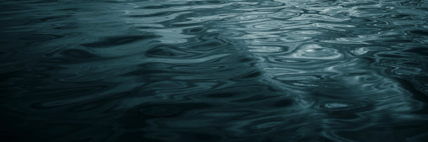 抽象的蓝绿色背景。阳光在波浪形水面上的反射图片下载