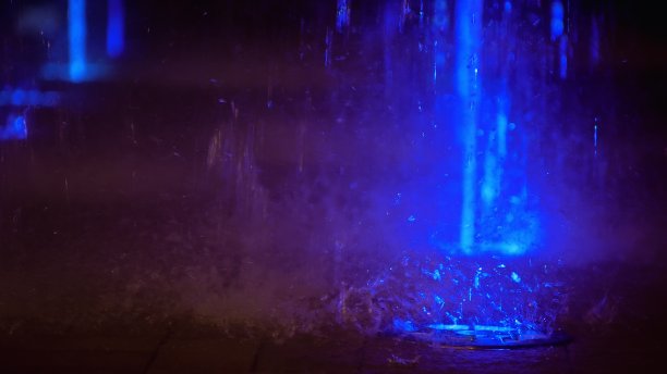 喷溅着五彩缤纷的喷泉。水被照亮，以不同的颜色落在一个喷泉，改变其水的颜色在夜晚。图片下载