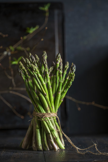 绿色芦笋的新鲜茎在深色木质背景上。宏视图，复制空间图片下载