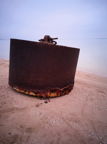 一个生锈的旧燃料容器坐落在红海的海岸上。特写镜头。图片下载