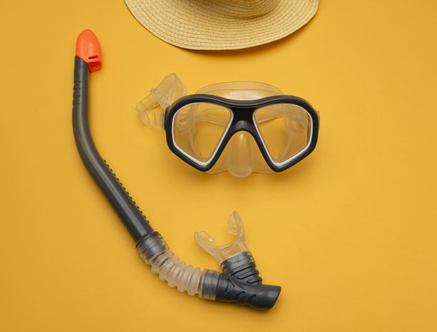 带通气管的潜水面罩和帽子，黄色背景。图片下载
