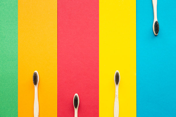 有机竹制牙刷在明亮的多色背景上组成。自然的口腔卫生。零浪费保护牙齿。图片下载