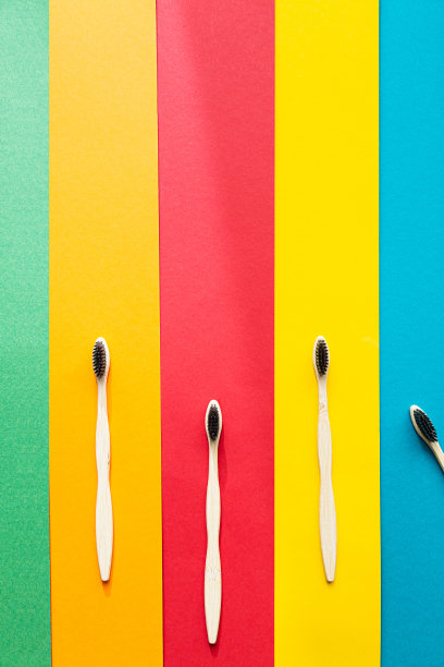 有机竹制牙刷在明亮的多色背景上组成。自然的口腔卫生。零浪费保护牙齿。图片下载