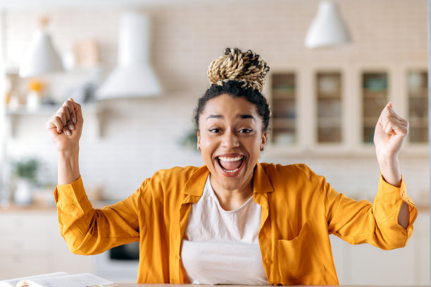 快乐迷人自信的年轻非洲裔美国女人的肖像，梳着脏辫，穿着休闲衣服，远程工作，表情激动，用手打手势，为好工作或新闻而高兴图片下载