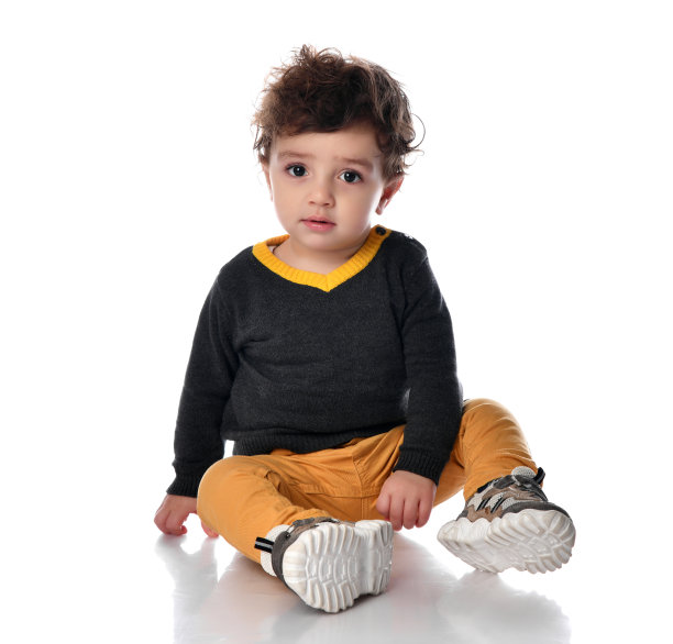 一个有着棕色大眼睛的男孩的肖像，他坐在白色的背景上，看着相机图片下载