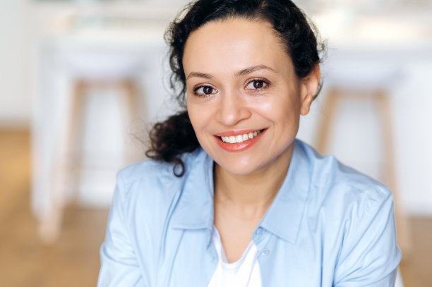 一个有吸引力的快乐自信的成年混血儿黑发女人的特写，商务女士穿着时髦的衣服，看着相机，可爱的微笑图片下载