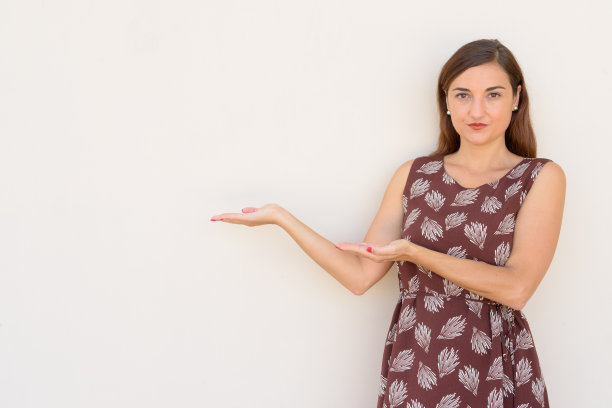 肖像美丽的女人在户外显示拷贝空间对着素色的墙图片下载
