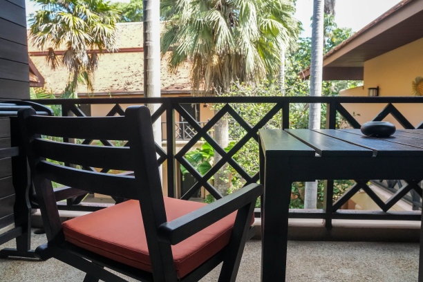 靠近剪影的木制椅子在酒店房间的室外露台吸烟图片下载