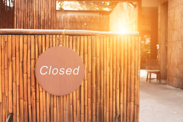 “对不起，我们关门了”的牌子挂在商铺后台门上素材图片