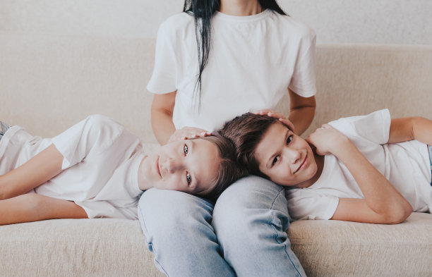 一个男孩和一个女孩躺在母亲腿上的巨大肖像。图片下载