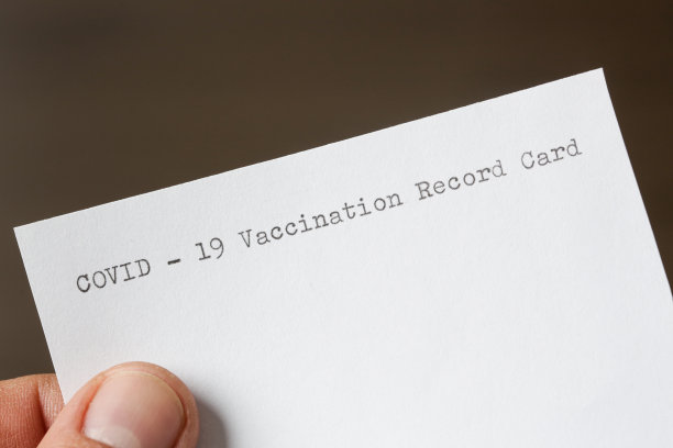 手持空白COVID-19疫苗接种记录卡的男子，特写图片图片下载