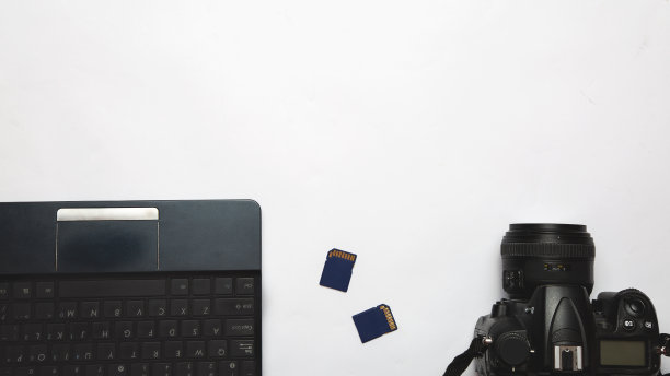 白色背景下的摄影师工作场所。现代笔记本电脑，数码相机，存储卡。前视图。副本的空间。摄影师的设备。自由职业的概念图片下载
