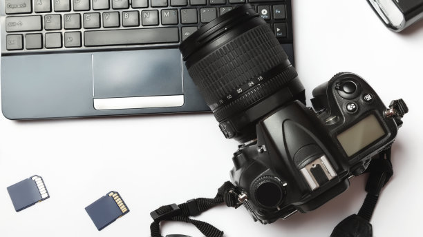 数码相机和笔记本电脑。工作场所的摄影师的概念。白色背景图片下载