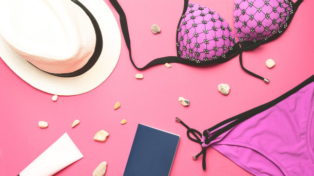 旅行的概念。夏日女性配饰帽子、泳装、泳装、护照以粉色为背景，夏日沙滩度假，平躺，俯视图。图片下载