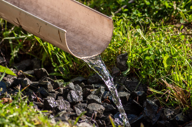 干净的水通过一个塑料滑槽流动。浇水用的水。图片下载