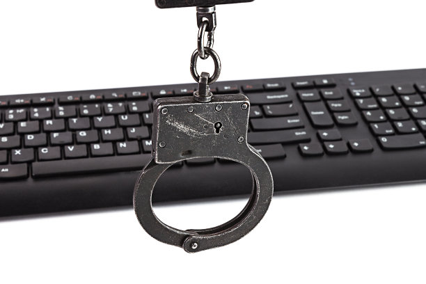 警察手铐和电脑键盘上的白色背景图片下载