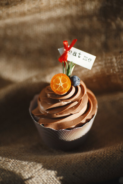 巧克力蛋糕在黑色的背景装饰金橘和蓝莓。食物的照片。图片下载