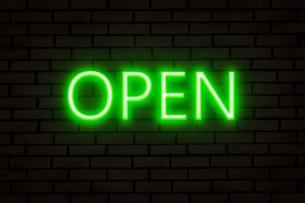 绿色的霓虹灯在砖墙上开放。图片下载