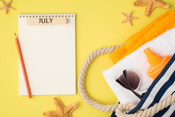 俯视图照片的计划与题词7月铅笔海星海滩袋与毛巾橙色瓶子防晒霜和太阳眼镜在孤立的黄色背景与空白空间图片下载